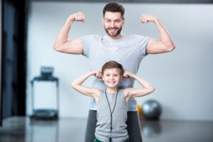 man and child showing muscles and strength