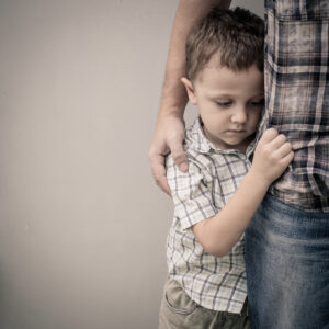 Young boy hugging father while feeling sad at drop-off