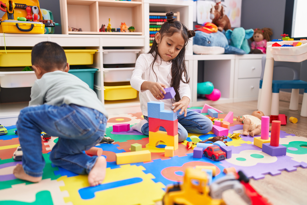 preschoolers stacking foam blocks on puzzle mat