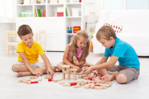 preschool girl and boy building colorful tower with foam blocks