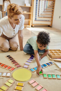 child playing with colorful learning tiles during class activity