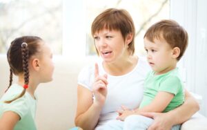 mother talking to young daughter and toddler son