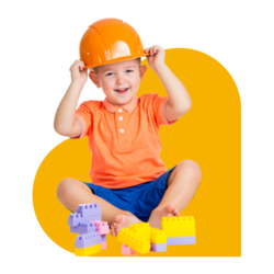 young boy wearing orange hard hat playing with building blocks