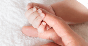 Parent gently holding newborn’s hand at Grateful Hearts Preschool, trusted infant preschool Las Vegas for care starting at 6 weeks