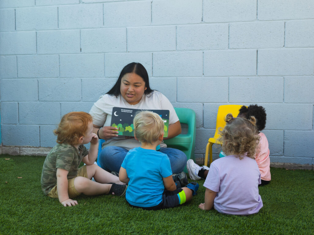 Teacher interacting with early preschool children in classroom