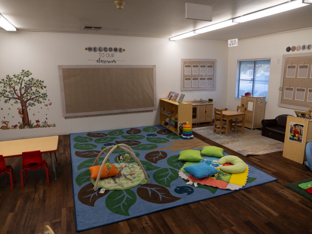 infant classroom reading nook with board books and soft seating