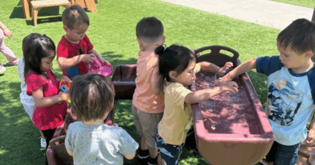 Toddlers exploring water play together at Grateful Hearts Preschool in Las Vegas, building social skills through hands-on play based learning.