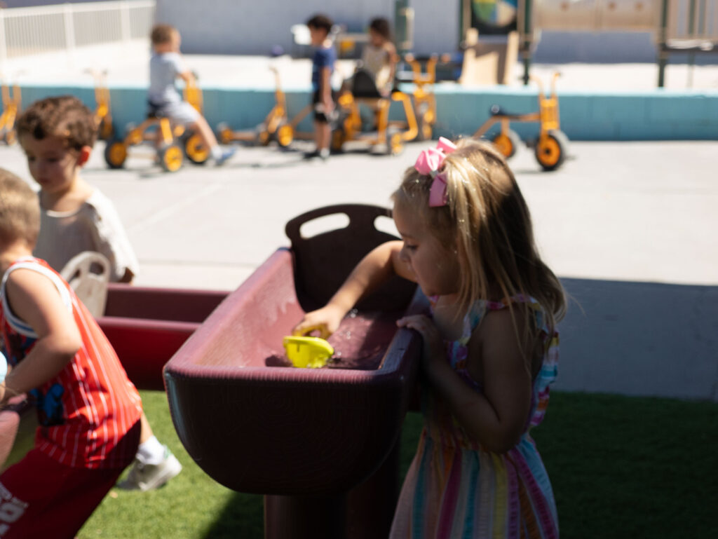 Pre-K students enjoying outdoor sensory water play at Grateful Hearts Preschool for Pre-K programs in Las Vegas